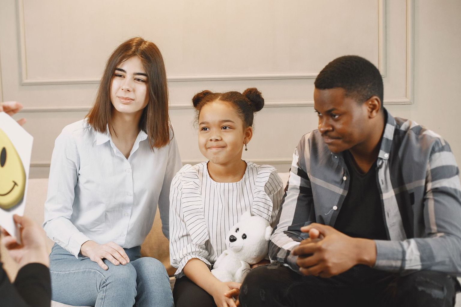 A family therapy session with a therapist, featuring parents and a child engaging in discussion.