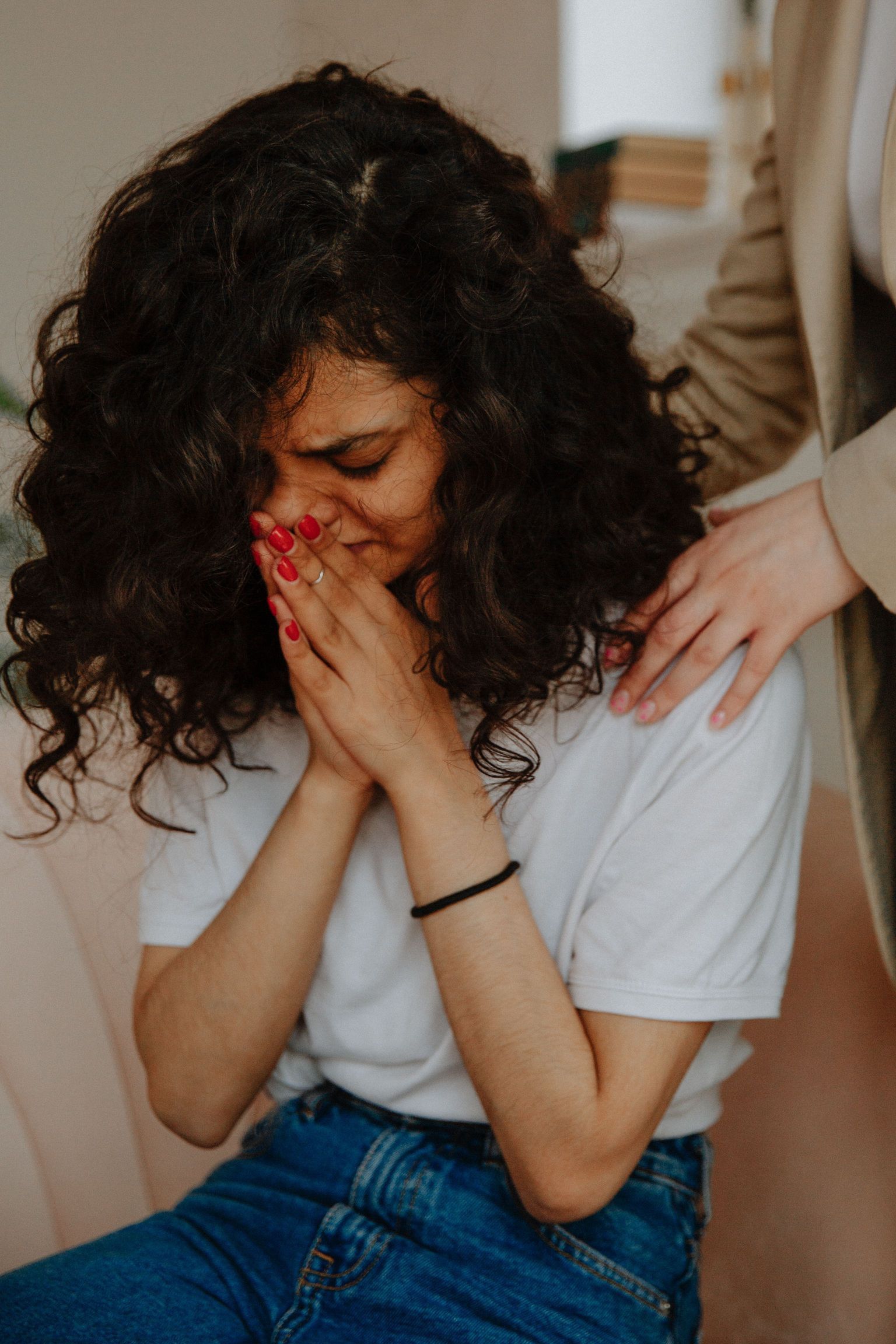 A young woman receives comforting support in a counseling session, highlighting empathy and mental health awareness.