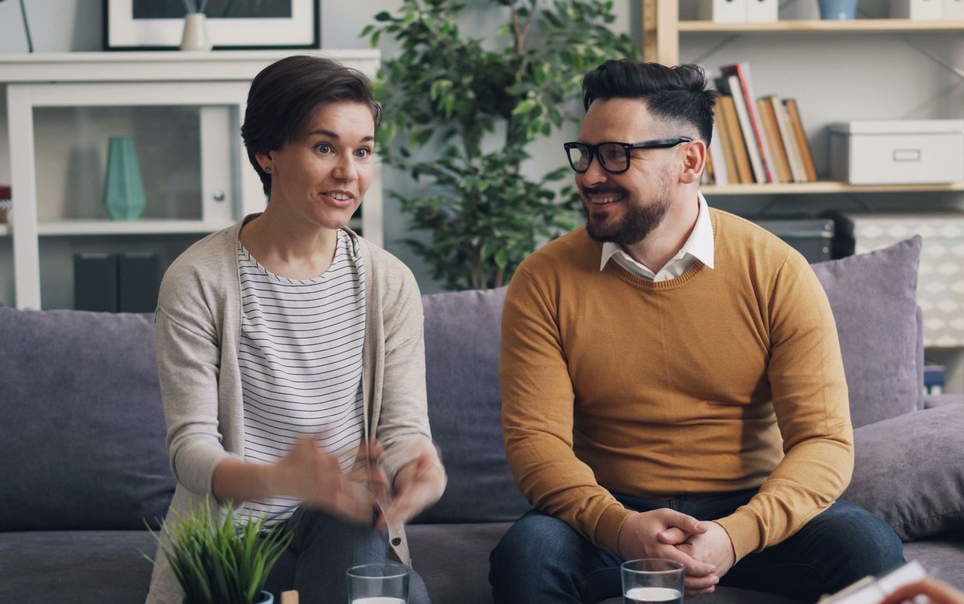 A couple discussing with a therapist during a counseling session indoors.